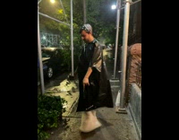 Man wears black and white trash bags for rain