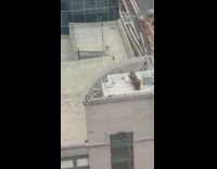 Two men photo shoot rooftop building edge