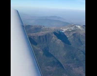 Airplane flies over mountains window wing