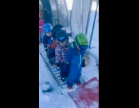 Kids practice for ski slides down snow