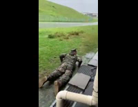 Soldier run dive on wet grass rain