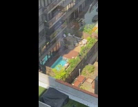 Person swimming in a small one person pool by apartment