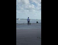 Man white short with dog beach overcast
