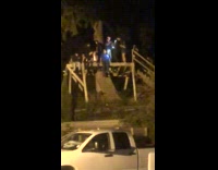Guy falls off balcony on tree at night