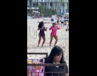 Two women beach wear dances for video