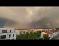 Rainbow arc passes through thick gray clouds