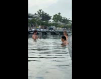 Man takes picture of woman outdoor balcony pool