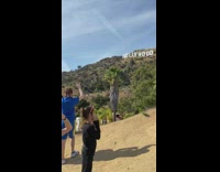 Girls pose by hollywood sign blue shirt