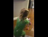 Little girl pushes cat through house stroller