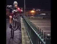 Guy does a wheelie then jumps over a spiky fence on bicycle
