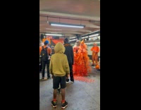 People in orange outfit models at subway