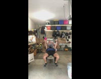 Guy lifts bar with two wood pieces 