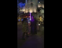 Guy with purple lightsaber takes picture at Disneyland