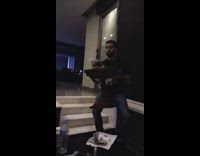 Guy lifts small dog on wooden podium 