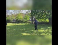 Girl tackles guy holding white rugby ball 