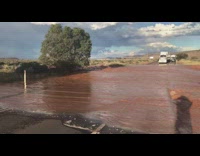 Brown rushing flood water block road traffic