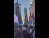 People Celebrate and Sing at Time Square Plaza