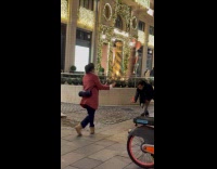 Woman red jacket dances inside the mall
