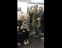 man holds wolf stuffed animal in green jacket