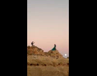 Collab IITW - Woman green dress poses beach rock top