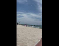 Three men hold hands jump shot beach