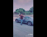 Guy lip sync orange flannel shirt car 