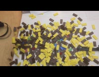 Guy stacks knocks over colorful dominoes tower