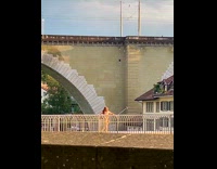 Woman in dress selfie stick at bridge