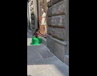 Woman in green skirt poses at the sidewalk