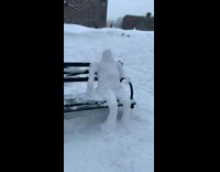 Snowman person sits on park bench 