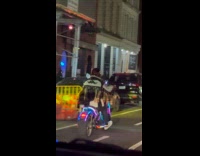 Man on motorcycle with tails on jacket