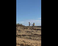 Man holds hands of the woman in front of the ruins