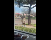 Woman checkered vest poses outside the restaurant