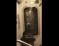 Guy wears colorful Native american headdress on subway train across cars