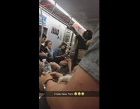 Man with cape and cardboard sign sings on subway train