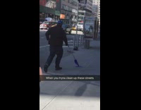 Guy walks sidewalk purple swiffer mop hat