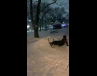 Guy skis down hill jumps over street