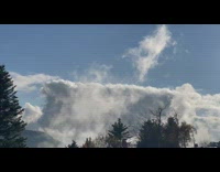 Clouds float just above mountain road cars
