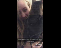 Girl tries to take sweater off cat 