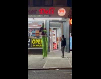 The Grinch on stilts dances on street