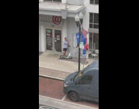 Guy with scooter selfie beside pizza shop