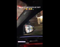 Guy holds on to back of moving bus 