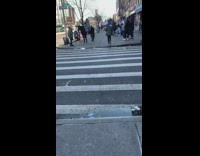 Guy sits on black horse on sidewalk 