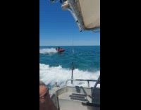 Two people ride red jet ski boat