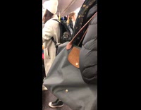 Dog inside backpack licks bag with zipper open on subway train