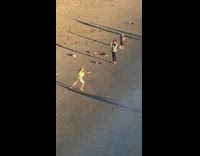 Girl in neon dancing on the beach 