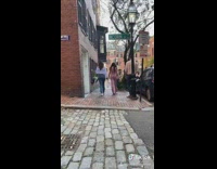 Two girls walk sidewalk white purse bag