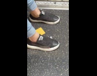 Womans pinky toe sticking out of black sneakers no shoelaces