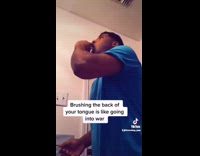 Guy gags while brushing back of tongue 