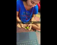 Woman peels vegetable in front of the laptop